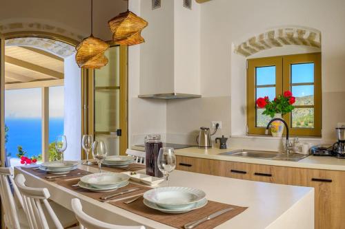 a kitchen with a table with plates and wine glasses at Manolis House in Sitia