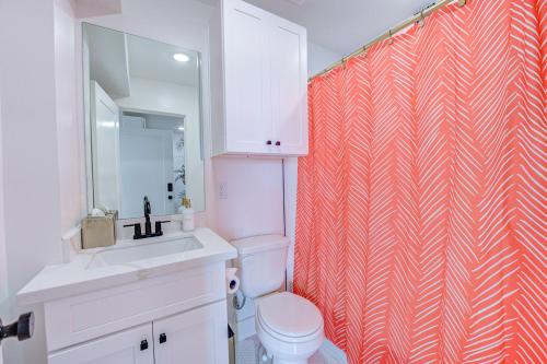 ein Badezimmer mit Toilette und Duschvorhang in der Unterkunft In Living Coral Studio Apartment in Galveston