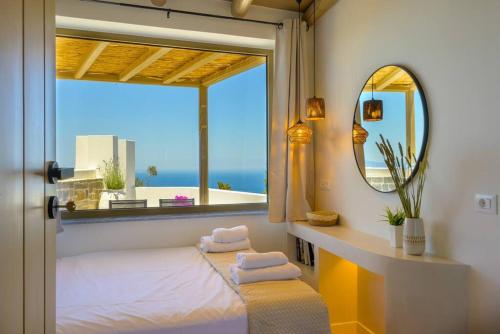 a room with a window with a bed and a mirror at Manolis House in Sitia