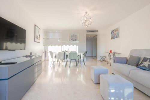 un salon blanc avec un canapé et une table dans l'établissement Le Parisien by Winsome Destination, à Cannes