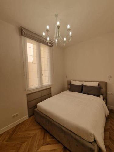 une chambre avec un grand lit et un lustre dans l'établissement Superb 1 Bedroom flat 2minutes from Monaco, à Beausoleil