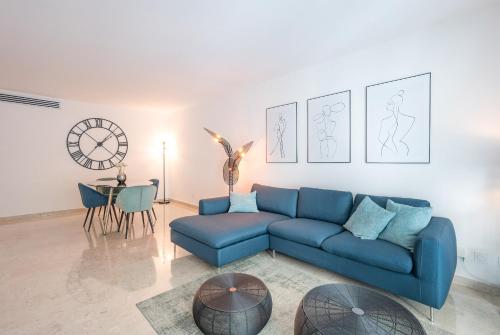 un salon avec un canapé bleu et une table dans l'établissement Le Dolce Vita by Winsome Destination, à Cannes
