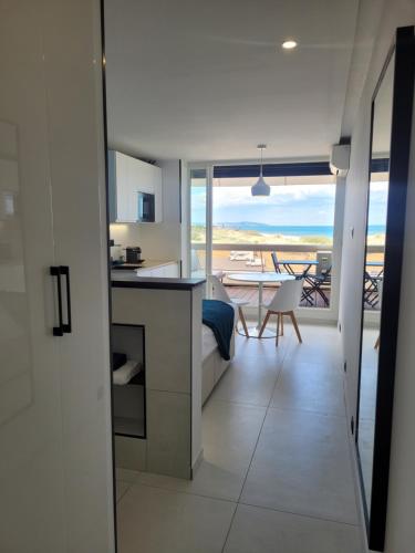 - une cuisine et une salle à manger avec vue sur l'océan dans l'établissement Blue Sand Luxe Vue Mer - Village Naturiste Résidence Héliopolis, au Cap d'Agde