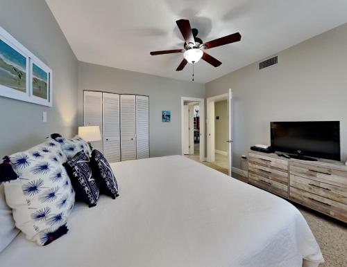 a bedroom with a white bed and a ceiling fan at Shipwatch Surf & Yacht #802A in Perdido Key