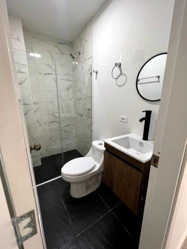 a bathroom with a toilet and a sink and a shower at Hotel Cabañas Villa Roca, Rodadero in Santa Marta