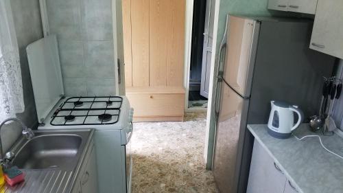 a small kitchen with a stove and a sink at Guest House Green Rose in Borjomi