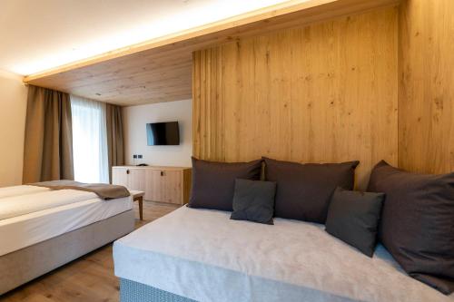 a hotel room with a bed and a couch at Hotel Lido - slow & natural living in Molveno