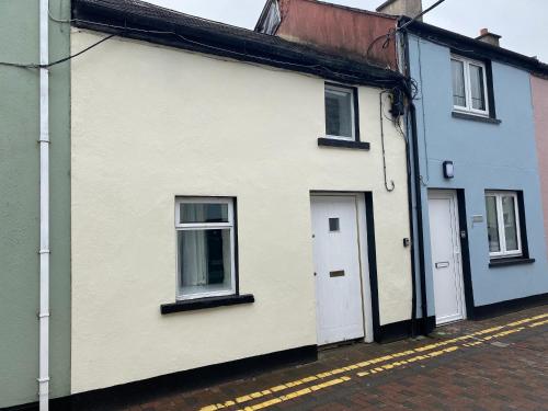a white house with two windows and a door at 2 Bed Townhouse Eyre Square City Centre in Galway