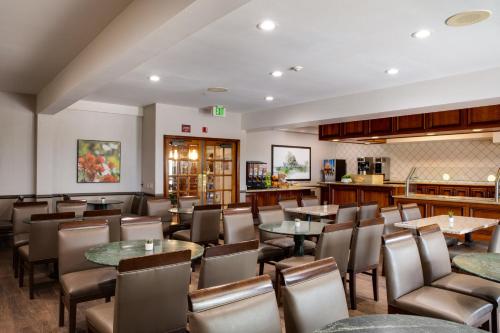 Un restaurante con mesas y sillas y un bar. en Ayres Suites Mission Viejo - Lake Forest, en Mission Viejo