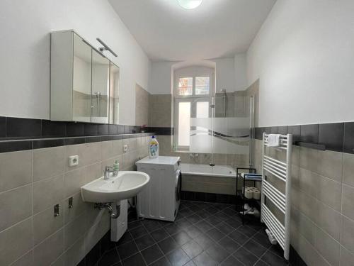 a bathroom with a sink and a bath tub at LUCKY STAYS LS01 - 2 Zimmer - Luxus - Zentrum - große Küche - Aufzug - Smart-TV in Magdeburg