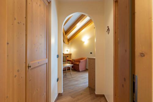 a hallway with an archway and a living room at Hotel Lido - slow & natural living in Molveno