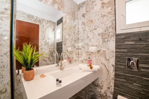 a bathroom with a sink and a mirror at Elena's Seaside Apartments & Studios in Agios Gordios