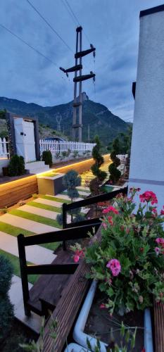 a bench with flowers in front of a building at Koman Paradise by Romina in Shkodër