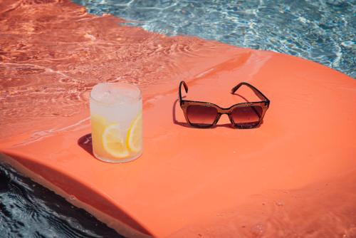 a pair of glasses sitting on an orange raft in a swimming pool at Mint House St. Petersburg - Downtown in St Petersburg