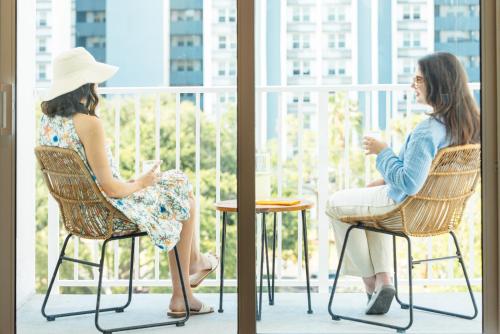 two women sitting in chairs on a balcony at Mint House St. Petersburg - Downtown in St Petersburg