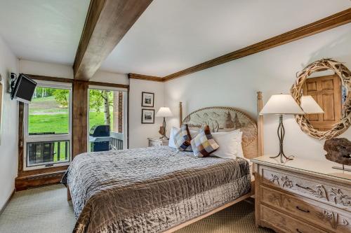 a bedroom with a large bed and a window at Interlude Condominiums 2-Bedroom Unit 205 in Snowmass Village