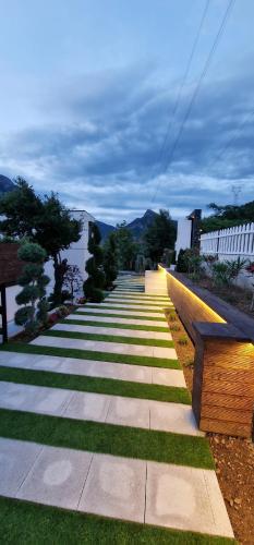 a walkway with a bench on the side at Koman Paradise by Romina in Shkodër