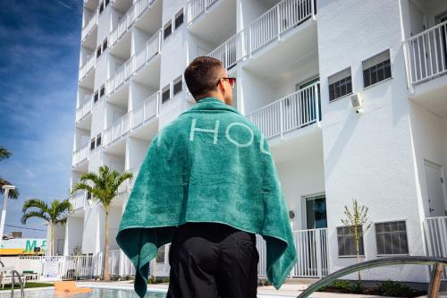 a man wearing a green jacket standing in front of a building at Mint House St. Petersburg - Downtown in St Petersburg