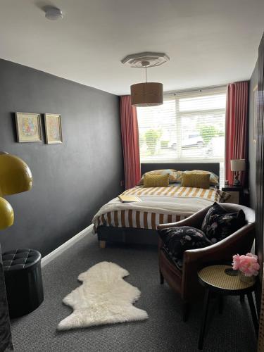 a bedroom with a bed and a couch and a chair at The Big Slepe in St. Ives