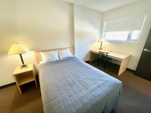 Habitación de hotel con cama, escritorio y ventana en Residence & Conference Centre - Ottawa Downtown en Ottawa
