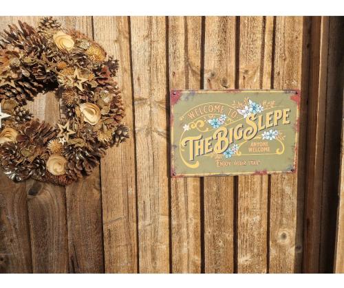 a sign on a wooden fence with wreaths on it at The Big Slepe in St. Ives