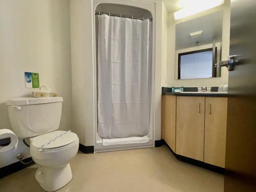 ريزيدنس آند كونفيرنس سنتر - أوتاوا داون تاون في أوتاوا: حمام به مرحاض أبيض ومغسلة