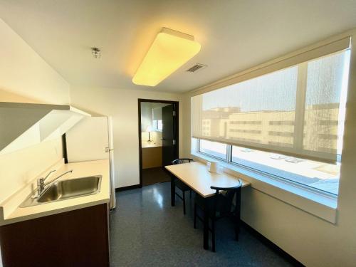 a kitchen with a sink and a table and a window at Residence & Conference Centre - Ottawa Downtown in Ottawa