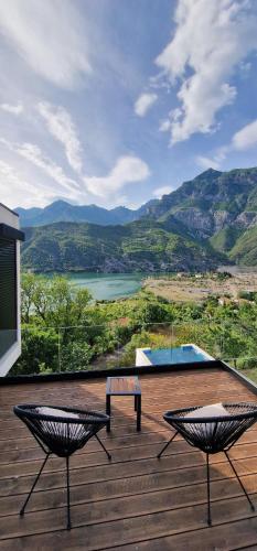 a deck with two benches and a view of a mountain at Koman Paradise by Romina in Shkodër