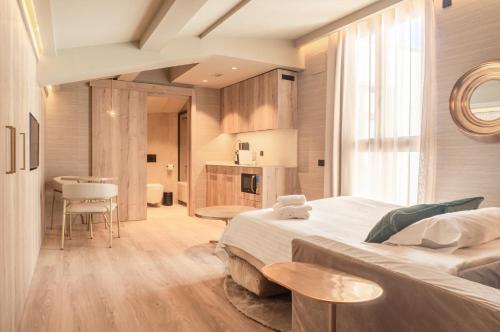 a bedroom with a large bed and a kitchen at The Valentia Corretgería in Valencia