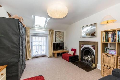 a living room with a fireplace and a tv at Fern Hse Grassington; central yet quiet & parking in Grassington