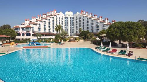 un hotel con una gran piscina frente a un edificio en Green Max Hotel, en Belek