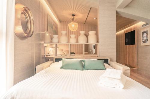 a bedroom with a bed with white sheets and vases at The Valentia Corretgería in Valencia