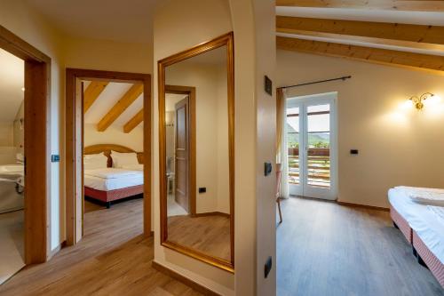 a large mirror in a room with a bedroom at Hotel Lido - slow & natural living in Molveno