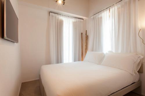 a white bed in a room with a window at Terra di Gradara in Gradara