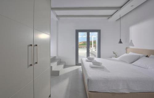 Un dormitorio blanco con una cama y una escalera. en Villa Indigo - Mykonos, en Mykonos ciudad