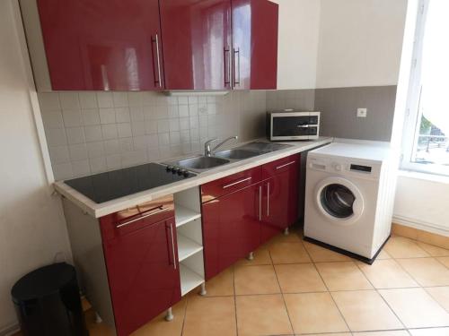 - une cuisine avec des placards rouges et un lave-linge dans l'établissement Bel appartement proche toutes facilités, à Nancy