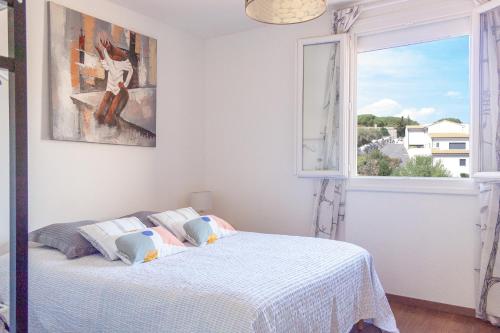 une chambre blanche avec un lit et une fenêtre dans l'établissement Villa Bougainvilliers, à Banyuls-sur-Mer