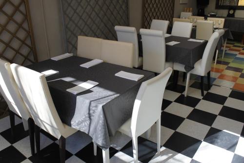 uma sala de jantar com uma mesa preta e cadeiras brancas em El Secreto del Júcar em Casas de Ves