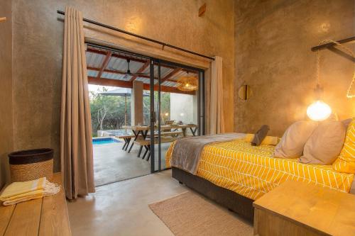 a bedroom with a bed and a sliding glass door at Ibhubesi house in Marloth Park