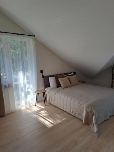 a bedroom with a large bed and a table at Kurortas Apartments in Palanga