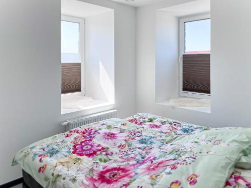 a bed in a bedroom with two windows at Hof Gemehret in Eupen