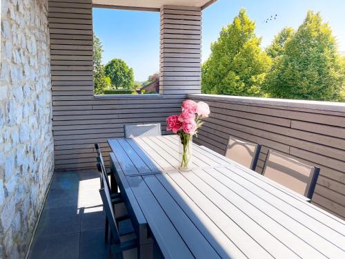 a vase of pink flowers sitting on a wooden table at Hof Gemehret in Eupen