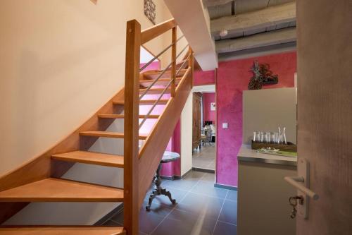 uma escada de madeira num quarto com uma cozinha em Gites de Climats de 3 à 6 personnes em Beaune