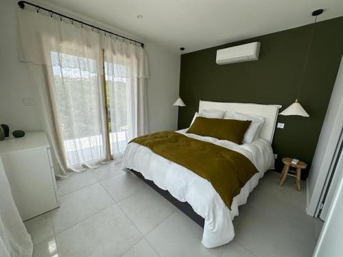 une chambre avec un grand lit avec un mur végétal dans l'établissement VILLA AVEC PISCINE LA GARRIGUE, à Nîmes