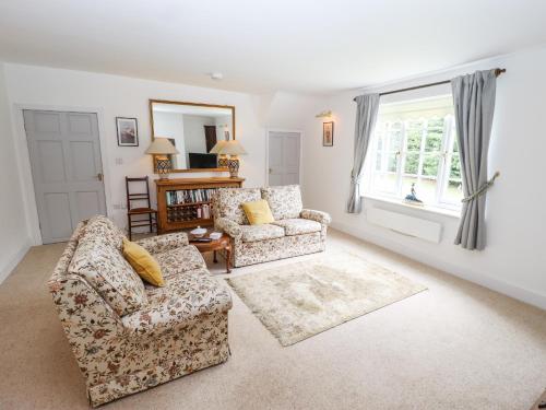 a living room with two chairs and a window at Pat's Cottage in Market Rasen