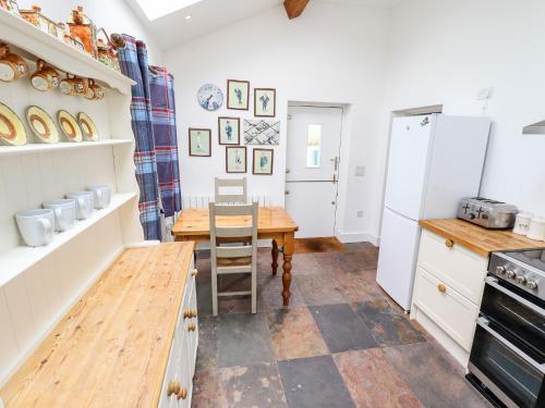 a kitchen with a wooden table and a dining room at Pat's Cottage in Market Rasen