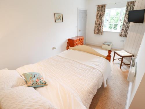 a bedroom with two twin beds and a television at Pat's Cottage in Market Rasen