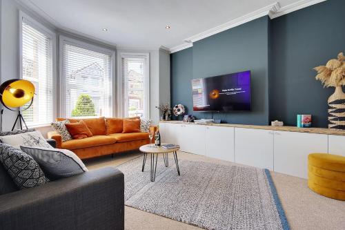 a living room with a couch and a tv at SeaEsta Stays -Game Room&VR &EV point in Bournemouth