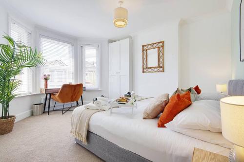 a white bedroom with a bed and a desk at SeaEsta Stays -Game Room&VR &EV point in Bournemouth