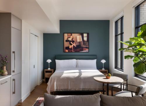 a bedroom with a bed and a table and chairs at ROOST Detroit in Detroit